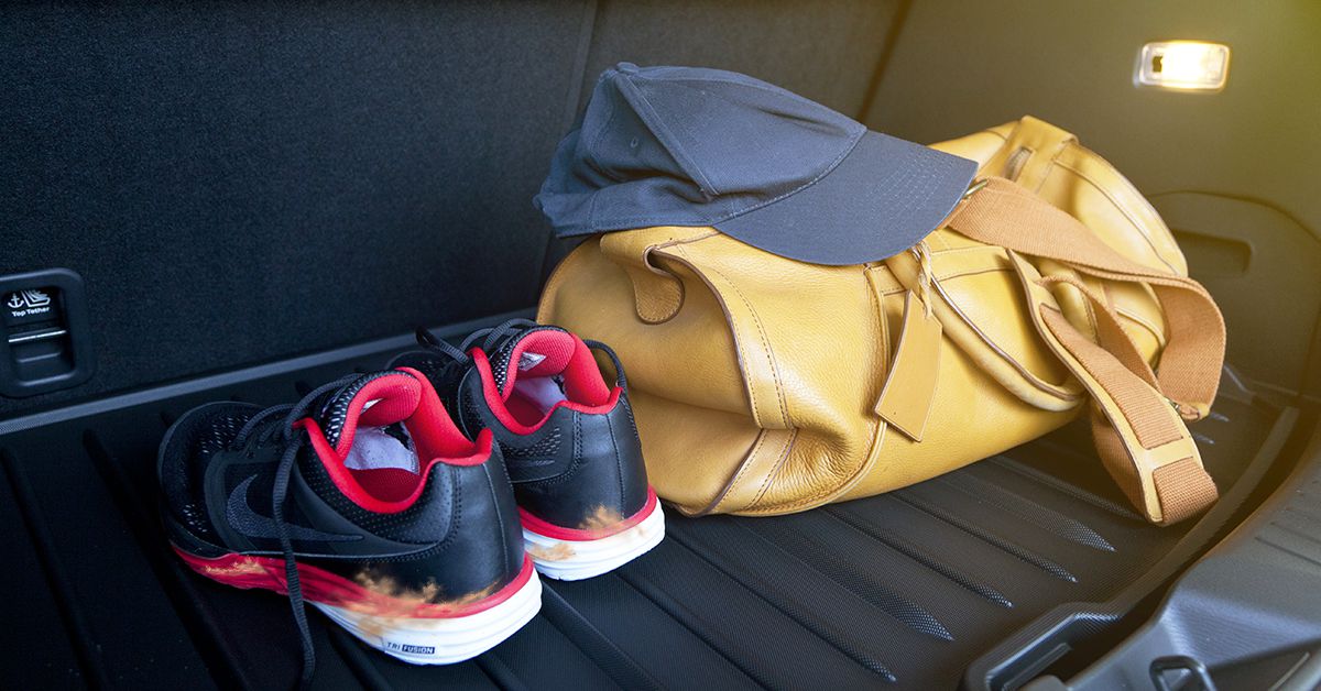 Muddy shoes and bag in the trunk of a car