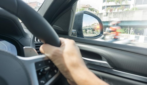 Car side mirror used to check blind spot before changing lanes safely