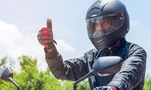 A man in a helmet and gloves on a motorcycle illustrating key safety considerations for helmet selection in Singapore