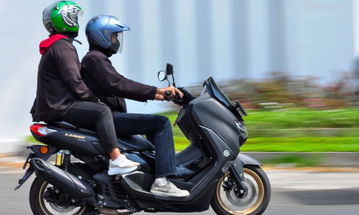 Two individuals on a motorcycle illustrating important safety tips for pillion riders in Singapore
